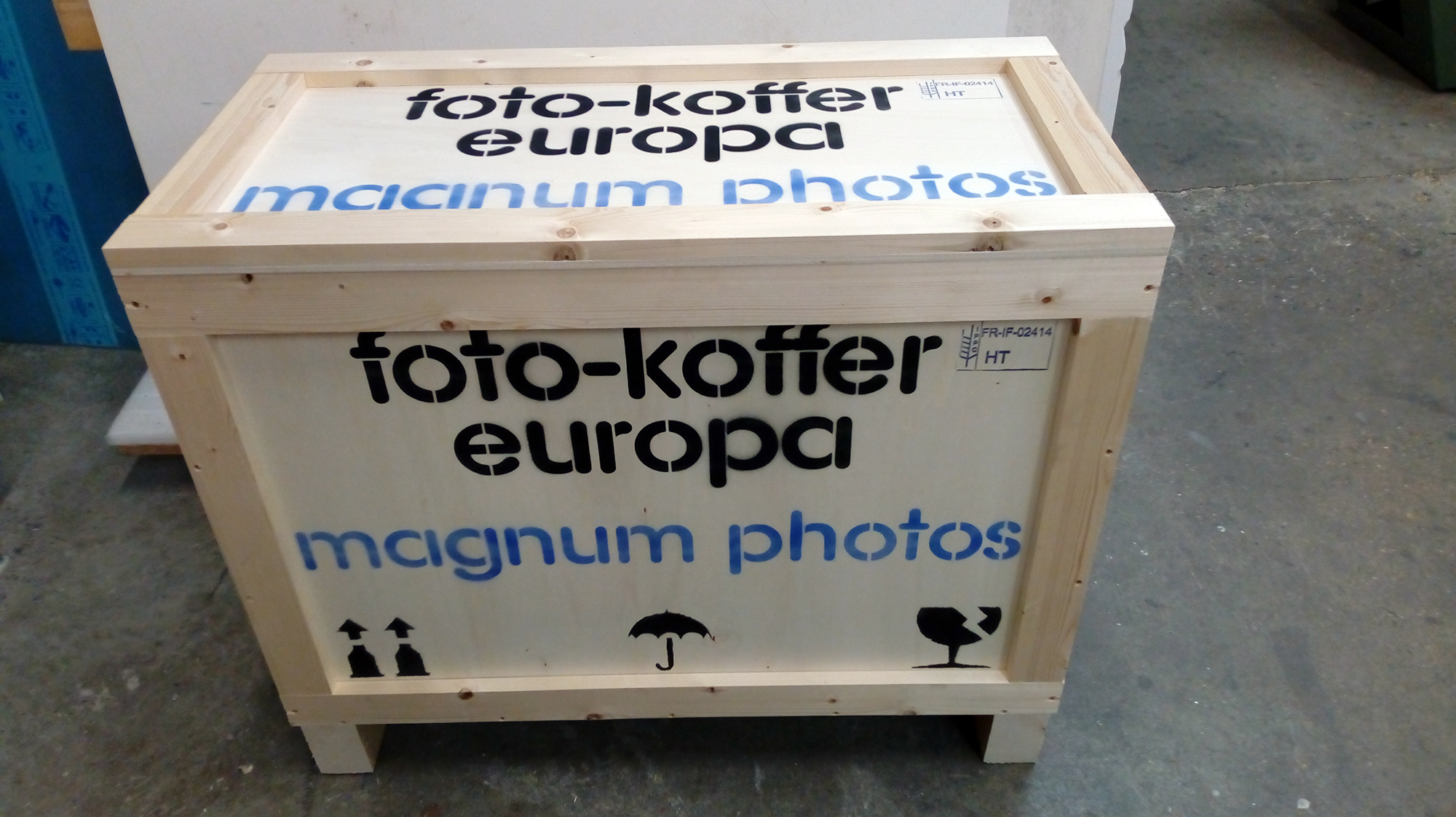 Ein großer Holzkoffer auf dem Boden mit der Aufschrift „Foto-Koffer Europa, Magnum Photo“